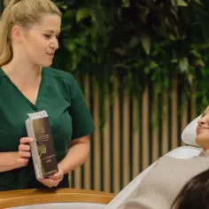 Kosmetolog prezentuje klientce Karisma Rh Collagen, stymulator tkankowy dla skóry twarzy.