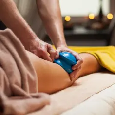 Masaż bańką chińską na udach. Terapeuta wykonuje zabieg, który ma na celu poprawę krążenia i redukcję cellulitu.