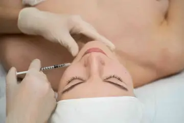 Zabieg botox na bruksizm. Delikatna igła wstrzykuje preparat w mięsień żwacz, przynosząc ulgę.